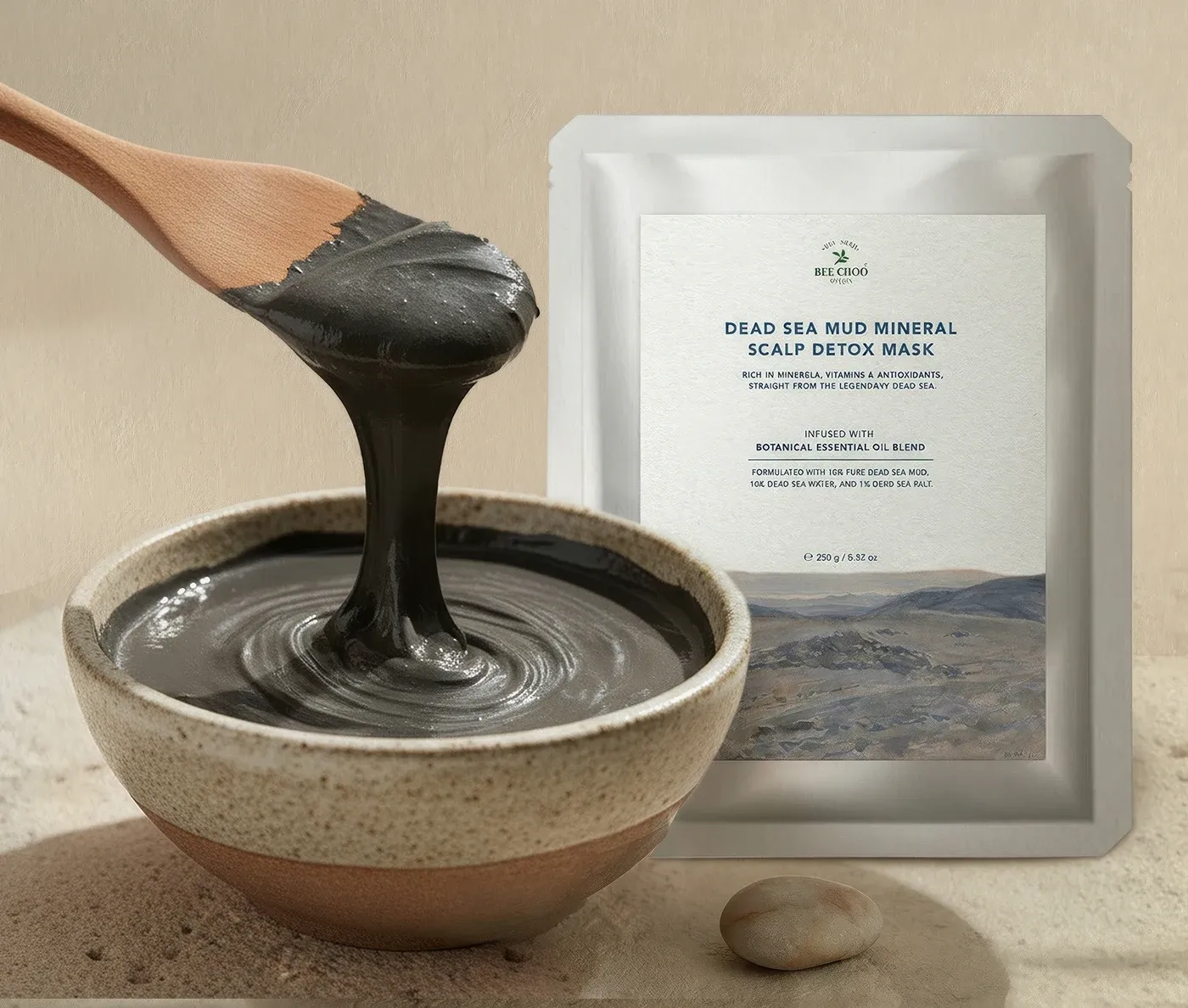 Dead Sea Mud Mineral Scalp Detox Mask pouch beside a bowl of mud and a wooden spatula